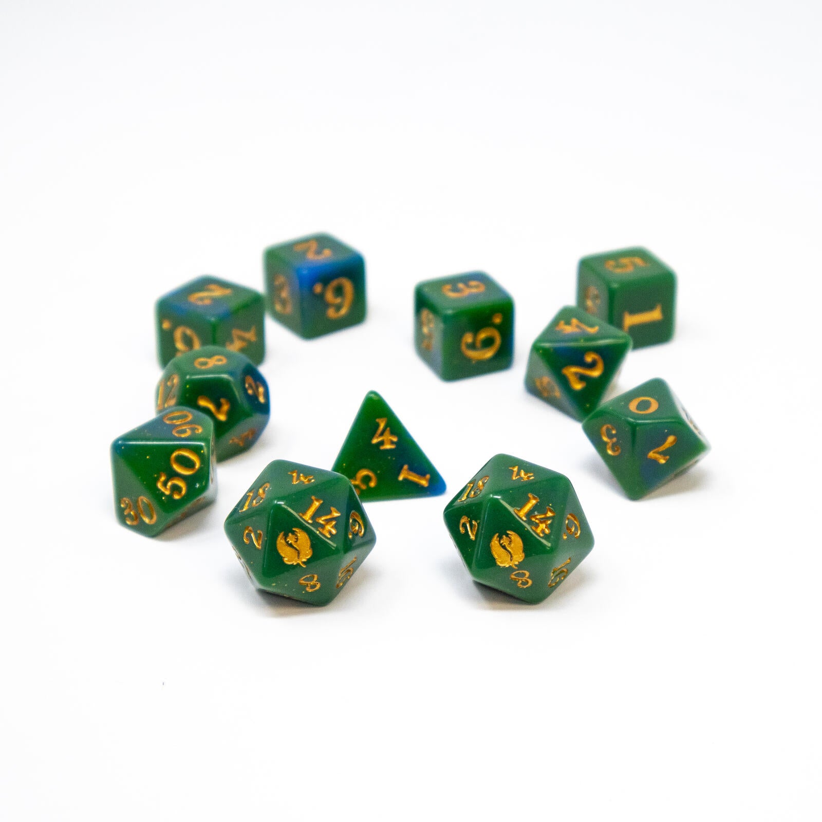 Assorted green and blue swirled polyhedral dice with gold numbers, including d4-d20, arranged on a white surface