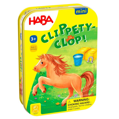Yellow HABA Clippety-Clop! mini game tin, featuring a prancing brown horse eating a carrot, hay, bucket, and horseshoe.