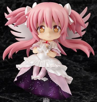 A chibi Ultimate Madoka figurine with pink hair, white wings, a ruffled white dress with starry purple underside, holding a white item