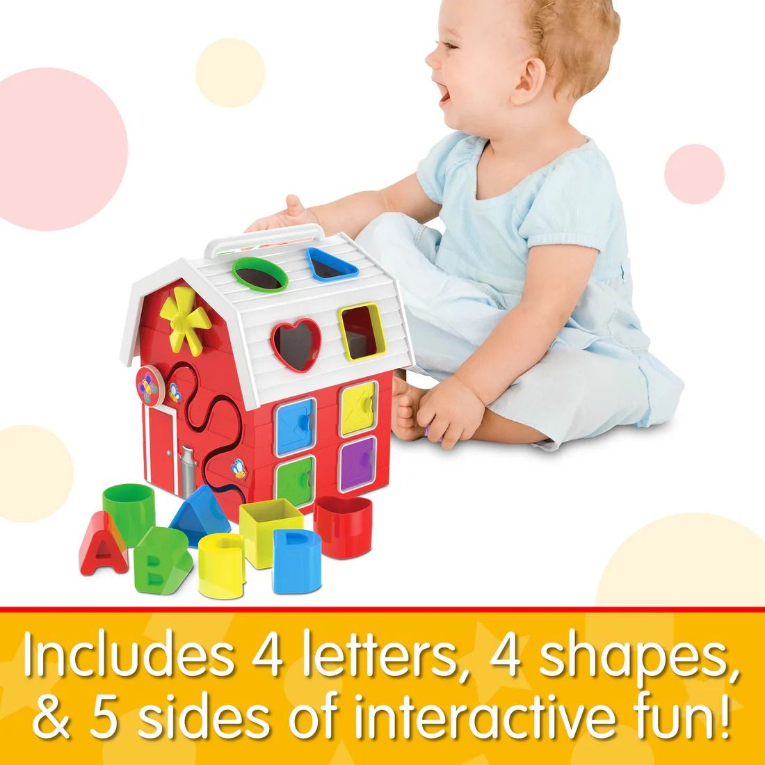 Smiling baby plays with a red barn shape sorter activity toy, featuring colourful blocks and letters