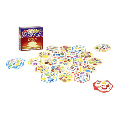 The Spot It! Catan game box stands beside a sprawling arrangement of hexagonal resource cards covered with unique Catan item icons