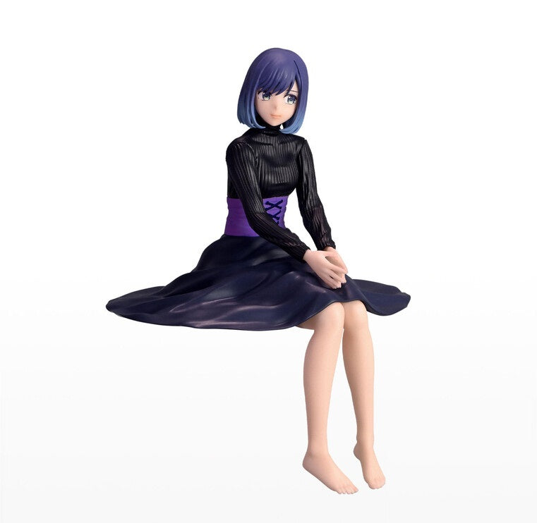 Seated figure with purple hair and blue highlights wearing a black ribbed shirt and long dark purple skirt