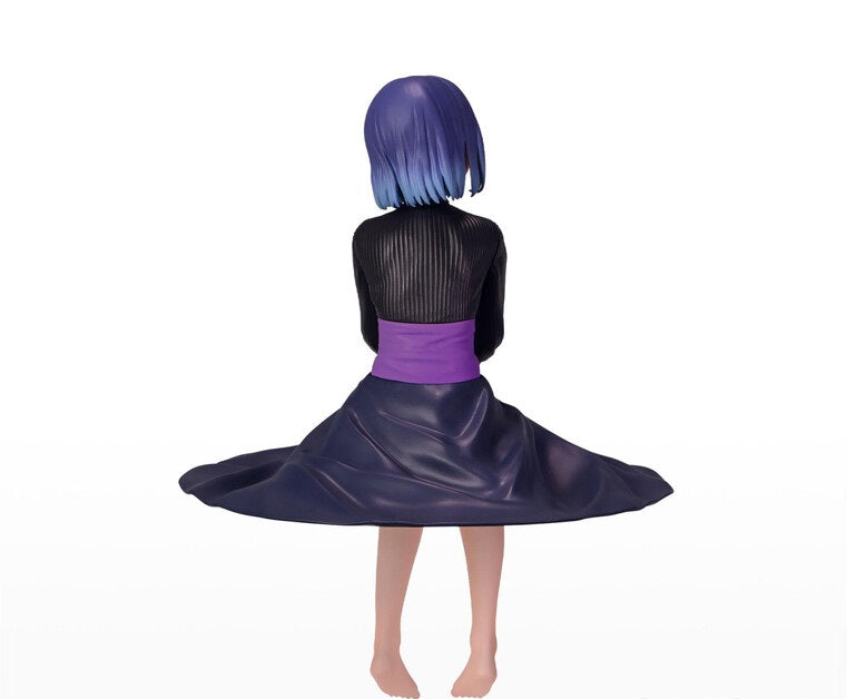 Back view of a figure with blue ombre bob hair black ribbed top and flowing dark purple skirt