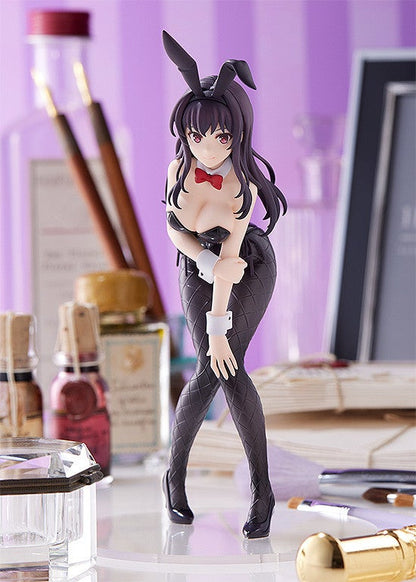 Beautiful dark haired figure in a black bunny suit with red bow tie and black textured tights