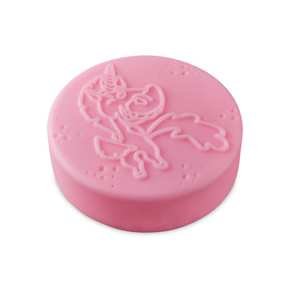 Pink circular bath bomb with a raised unicorn design and small scattered bubbles