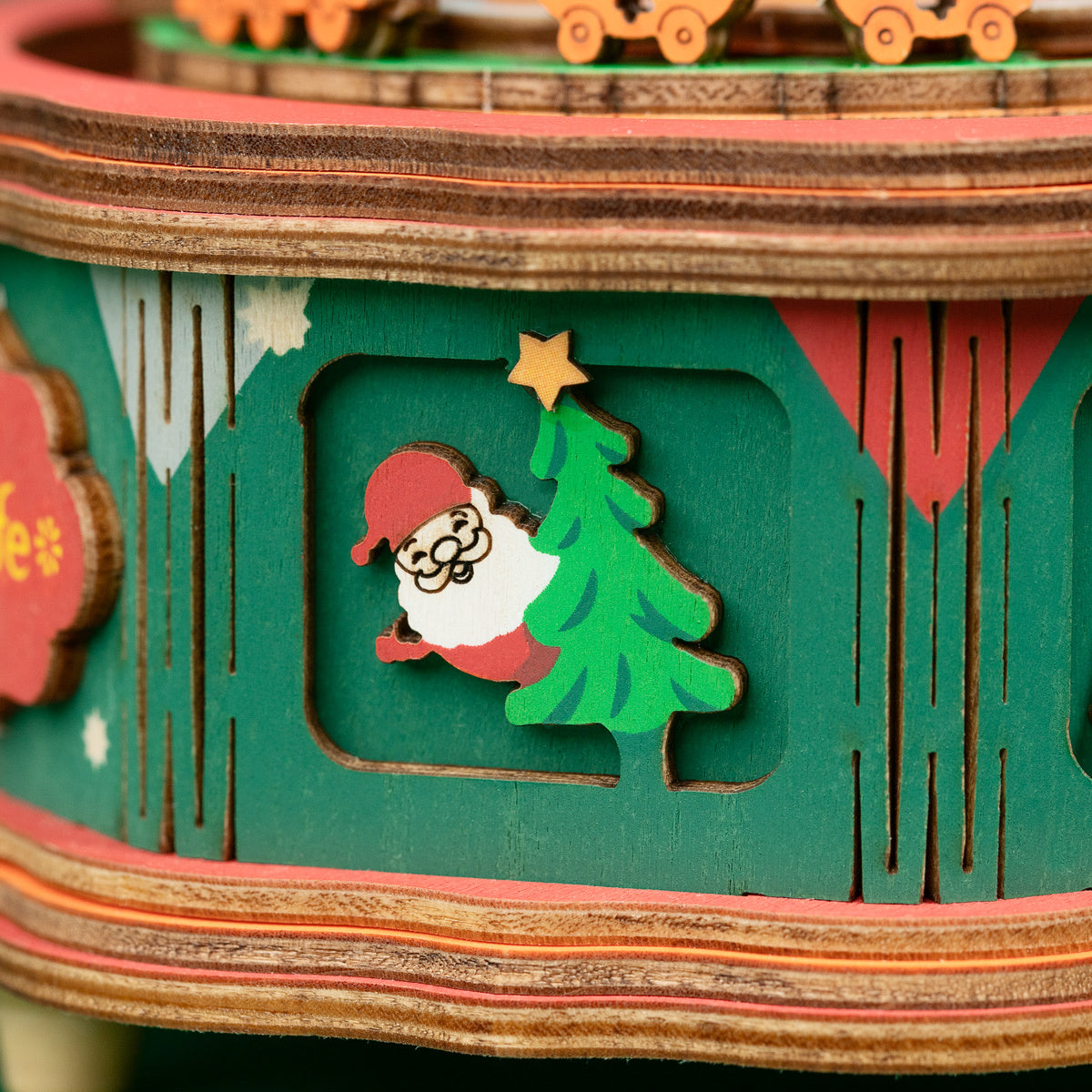 Close-up of a festive wooden panel decorated with a Santa Claus and Christmas tree cutout