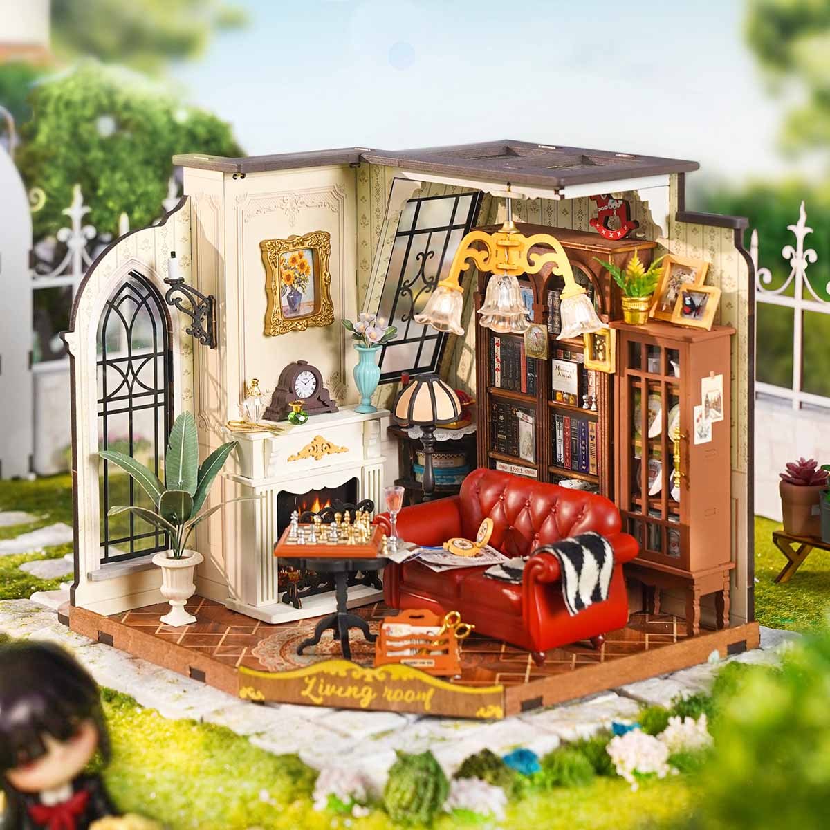 Detailed miniature model of a Catherines living room with a red sofa, fireplace, and bookcase
