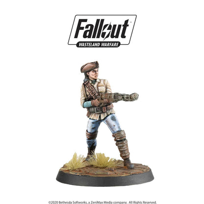A painted Fallout Wasteland Warfare female miniature in a hat and jacket aims a Gatling gun forward.