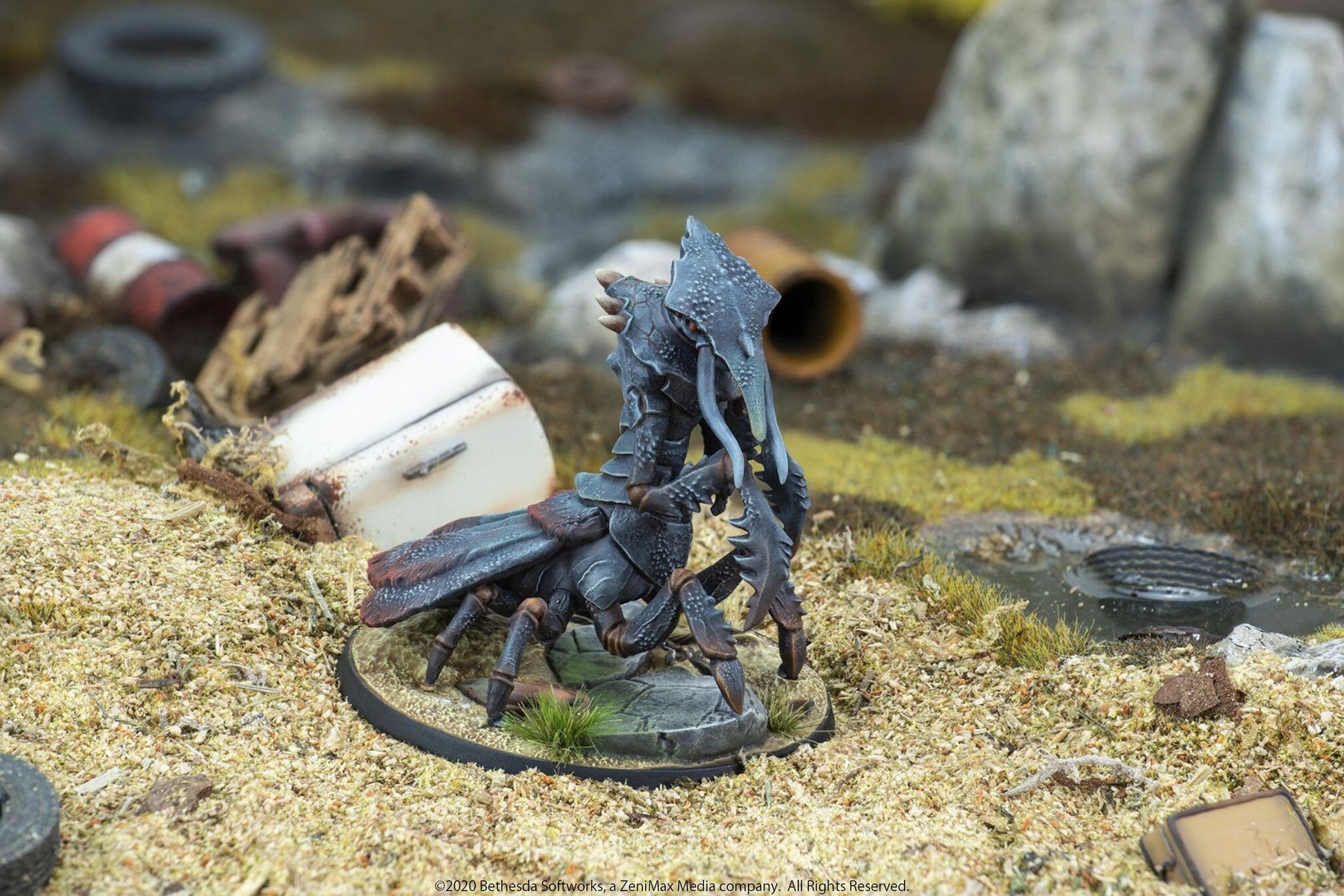 Miniature: Dark armored insectoid creature with large claws standing in a debris-strewn wasteland