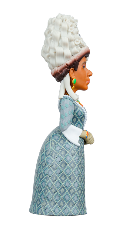 The MINIX Bridgerton Queen Charlotte Figure shows a woman with dark skin, a large white wig, green earrings, and a blue diamond-patterned dress
