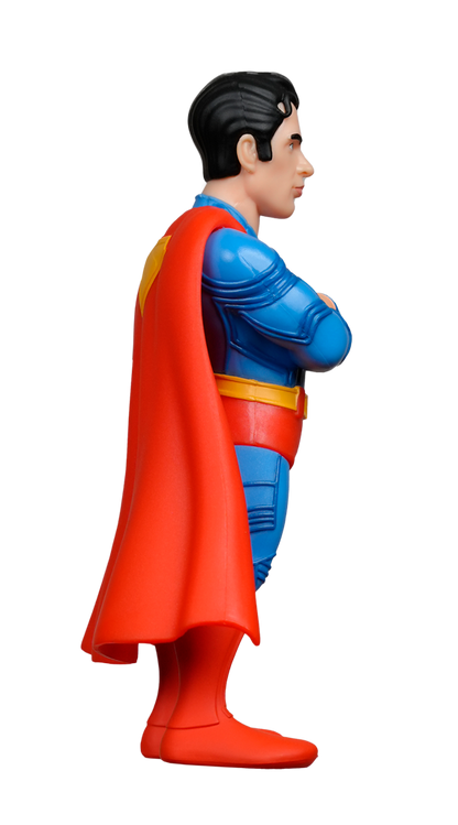 A side view of the MINIX DC Comics Superman 2025 Figure in a blue suit with red cape and boots, arms crossed