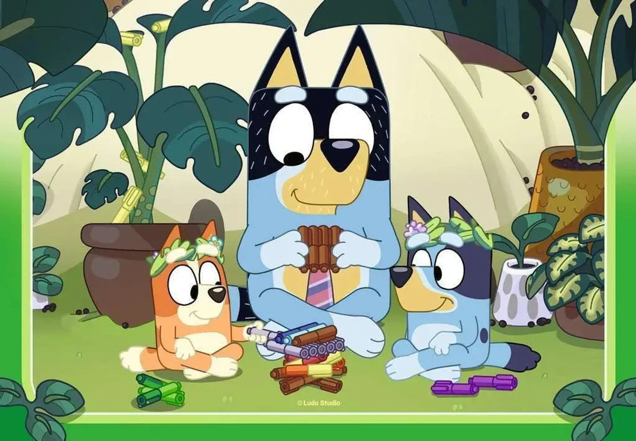 The Bluey family sits in a vibrant garden, with Bandit playing a pan flute and Bluey and Bingo wearing floral crowns surrounded by colorful sticks