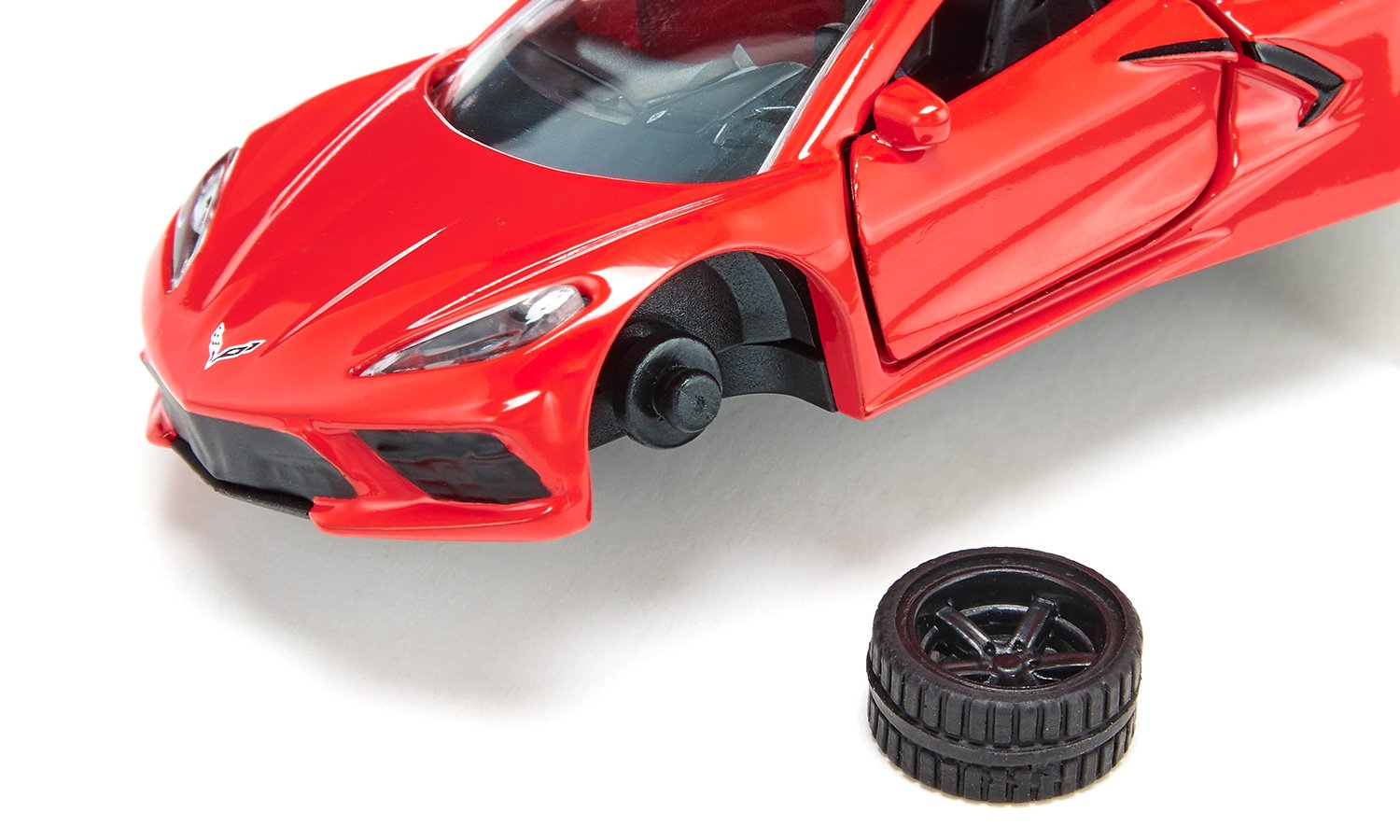 A red Chevrolet Corvette C8 Stingray toy car with its front left wheel detached, resting next to the car