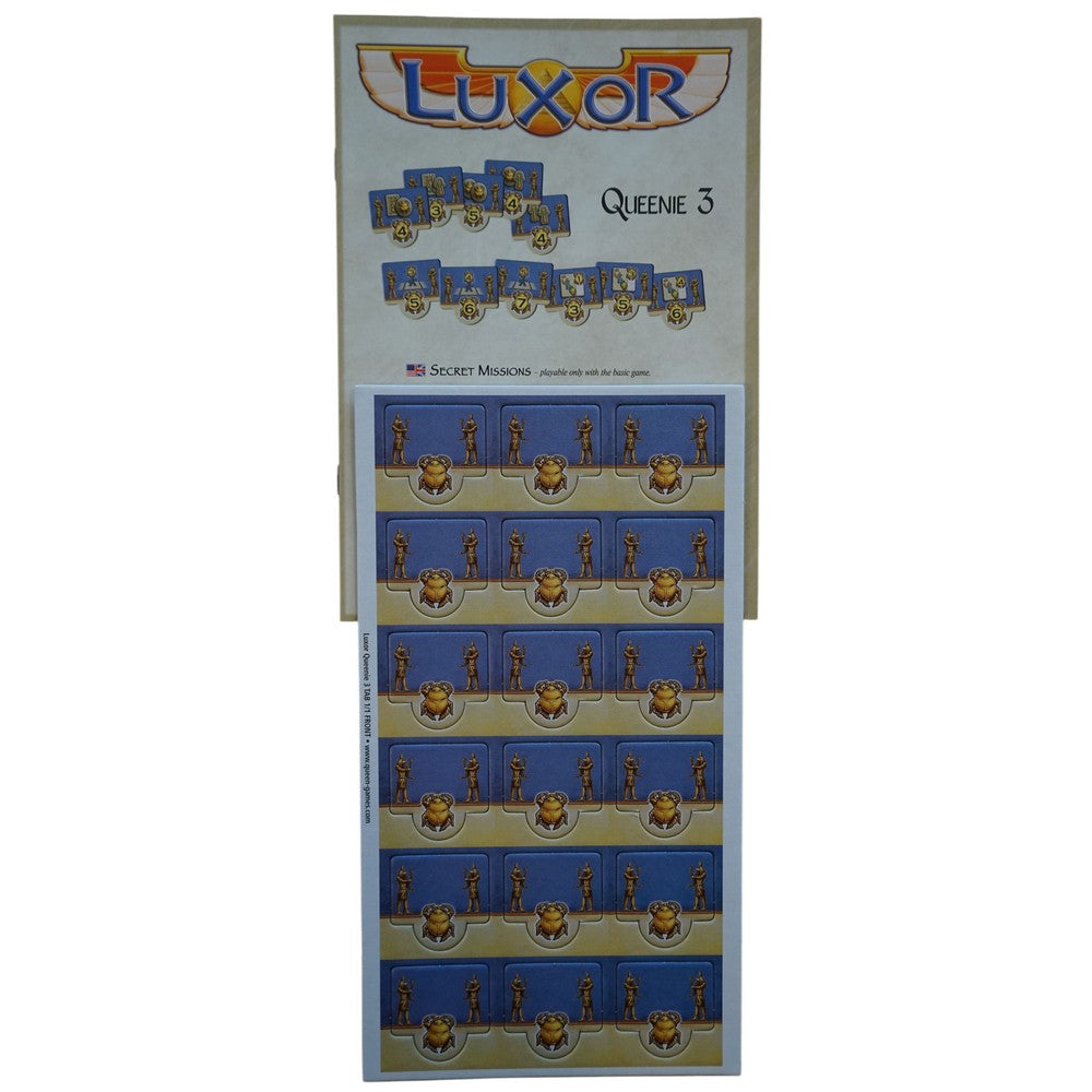 Luxor Queenie 3 board game expansion box, showing mission tiles and a punchboard of golden scarab and figure tokens