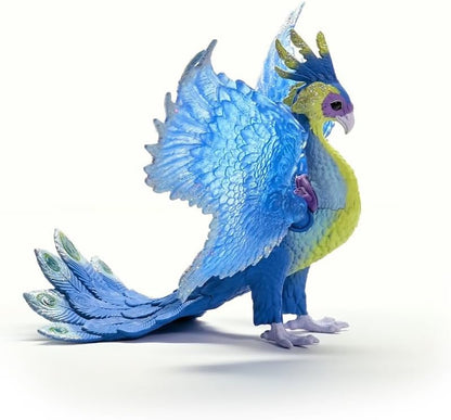 A glittery blue and yellow Magic Peacock figurine with large wings and a fanned tail stands on a white background