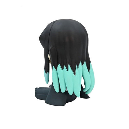 Black and teal figure with spiky hair sitting from a rear view
