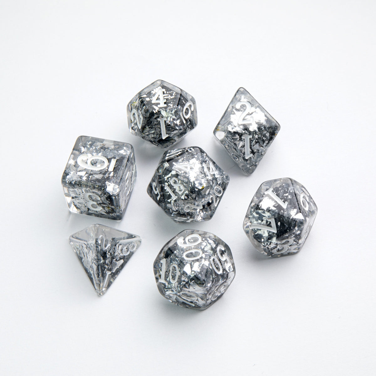 This Gamegenic Candy-like seven-dice RPG set in Blackberry color features clear smoky resin heavily infused with shimmering silver foil flakes and bright white numbers