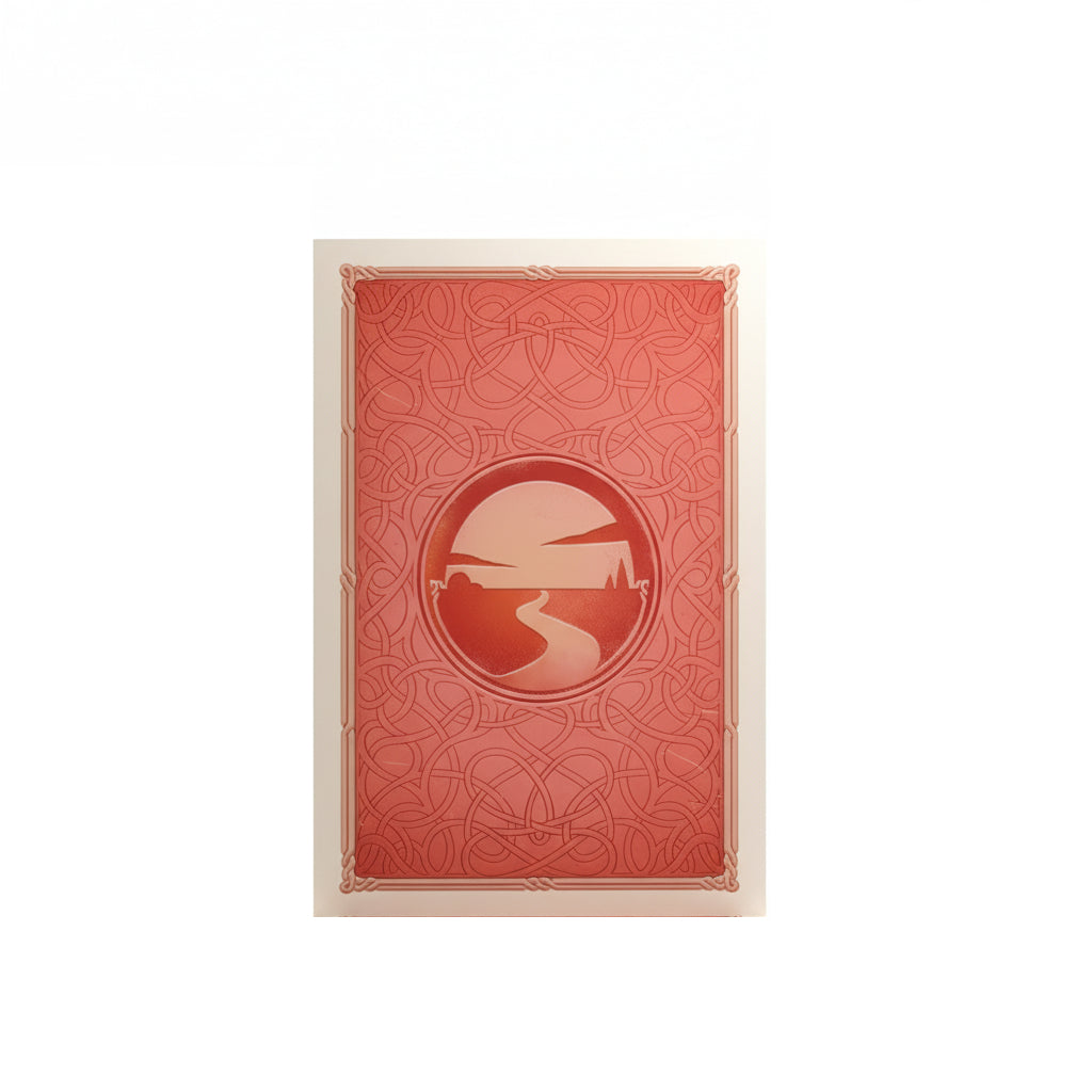 A red Catan art sleeve with a Celtic knot pattern and a central emblem showing a winding road towards a sunset landscape