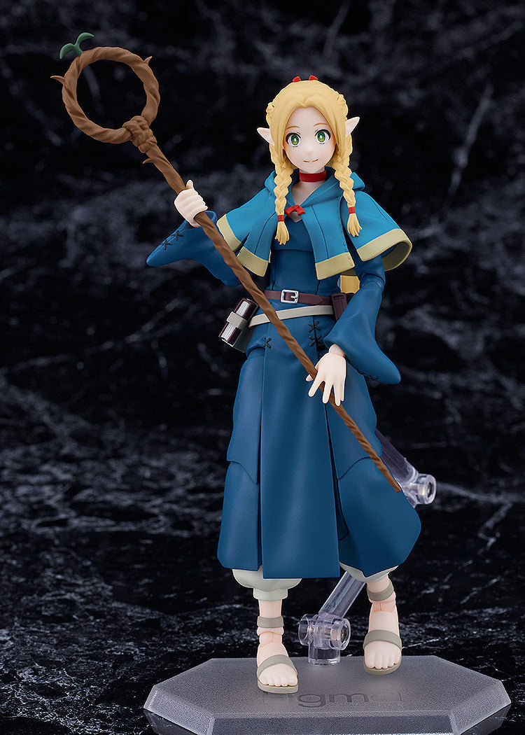 Figma Marcille figure from Delicious in Dungeon with blonde braids blue cloak staff and sandals posed on a clear hexagonal stand