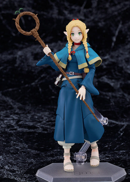 Figma Marcille figure from Delicious in Dungeon with blonde braids blue cloak staff and sandals posed on a clear hexagonal stand