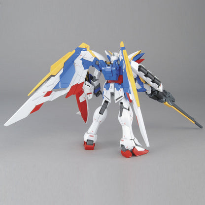 Multicoloured winged Gundam model kit, primarily white and blue, standing and holding a long rifle