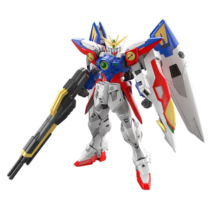 The assembled RG 1/144 Wing Gundam Zero figure, featuring white, blue, red, and yellow armor, holds its large twin buster rifle with majestic wings spread behind it