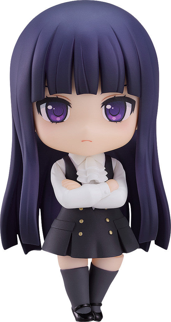 Nendoroid figure of a girl with long dark hair, purple eyes, in a white ruffled shirt and dark pinafore dress, arms crossed, frowning.
