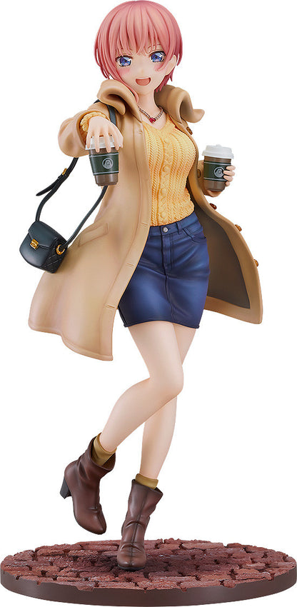 Anime figure of a woman with pink hair in a tan coat orange sweater denim skirt and brown boots holding coffee cups