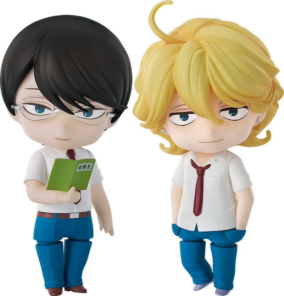 Two Nendoroid anime figures. One with black hair & glasses holds a book; the blonde-haired one smiles