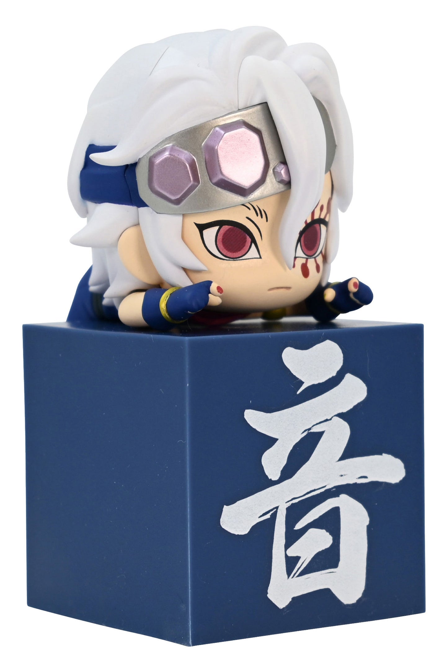 Chibi anime figurine with white hair and red eyes wearing a silver headband sitting on a blue block with white Japanese characters