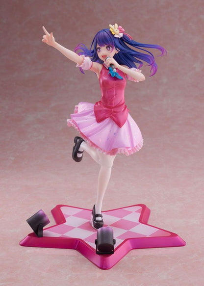 Anime idol figure with blue hair pink dress and yellow flower hair and standing on a star-shaped stage