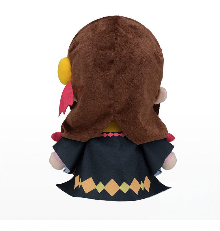 Back view of a brown hooded plush wearing a dark coat with yellow and orange diamond pattern on the trim