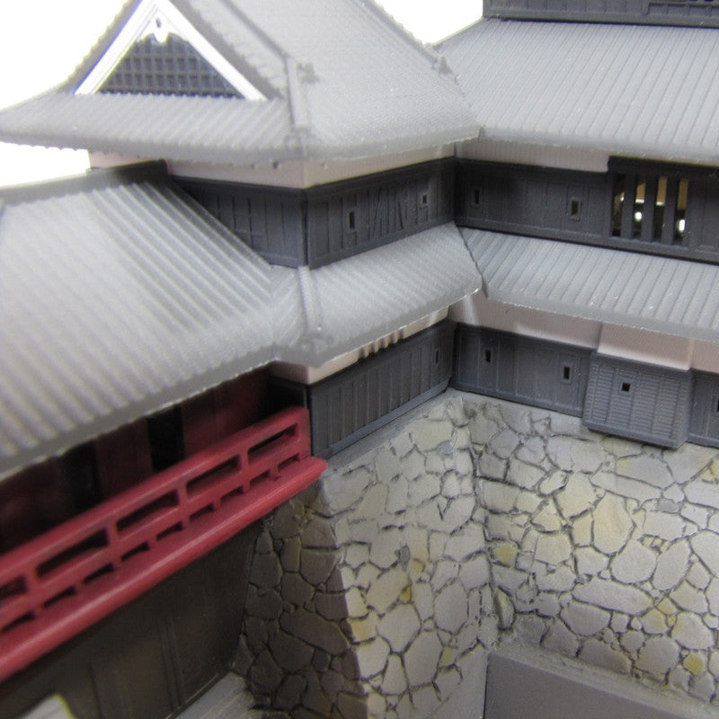 Detailed scale model of a traditional Japanese castle section featuring grey tiled roofs black walls