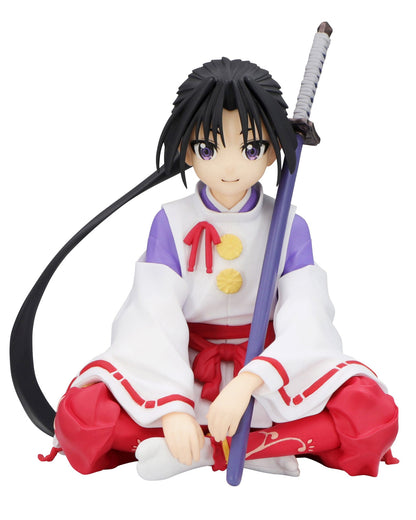 Figure in red and white kimono with sword sitting cross-legged