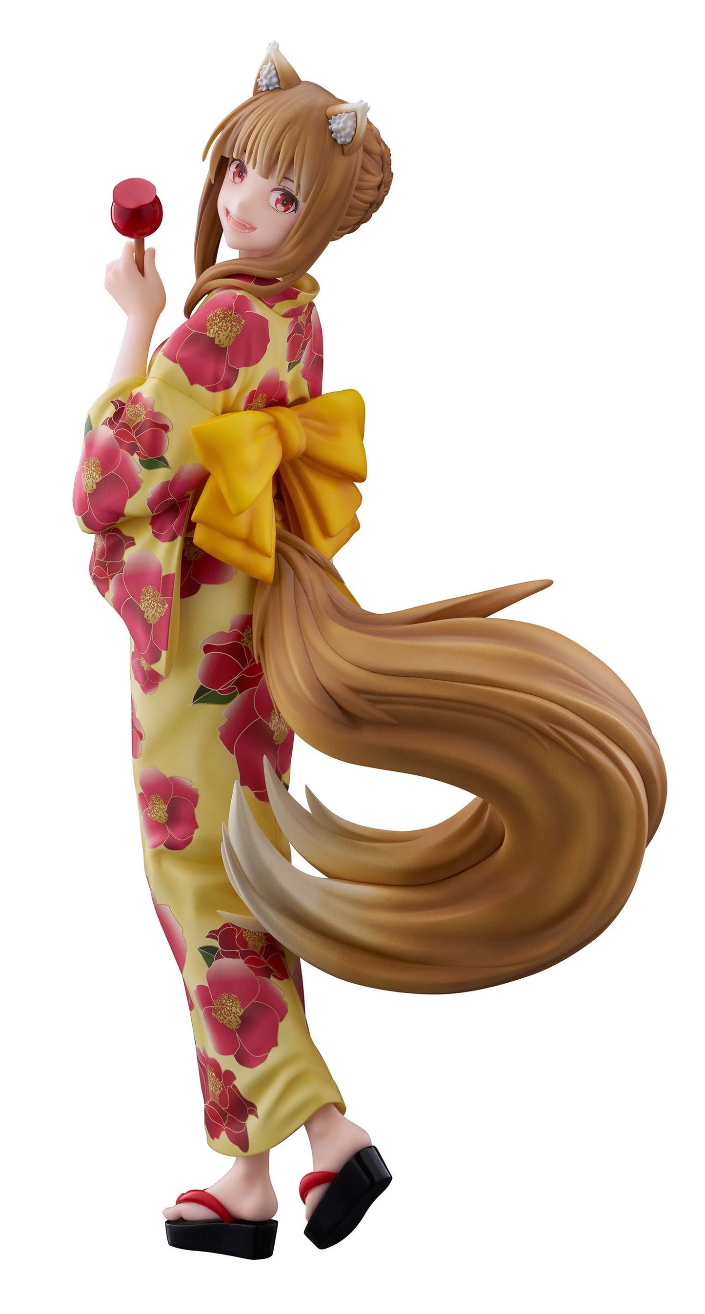 A smiling anime figurine with fox ears and tail in a yellow floral kimono, holding a red candy apple