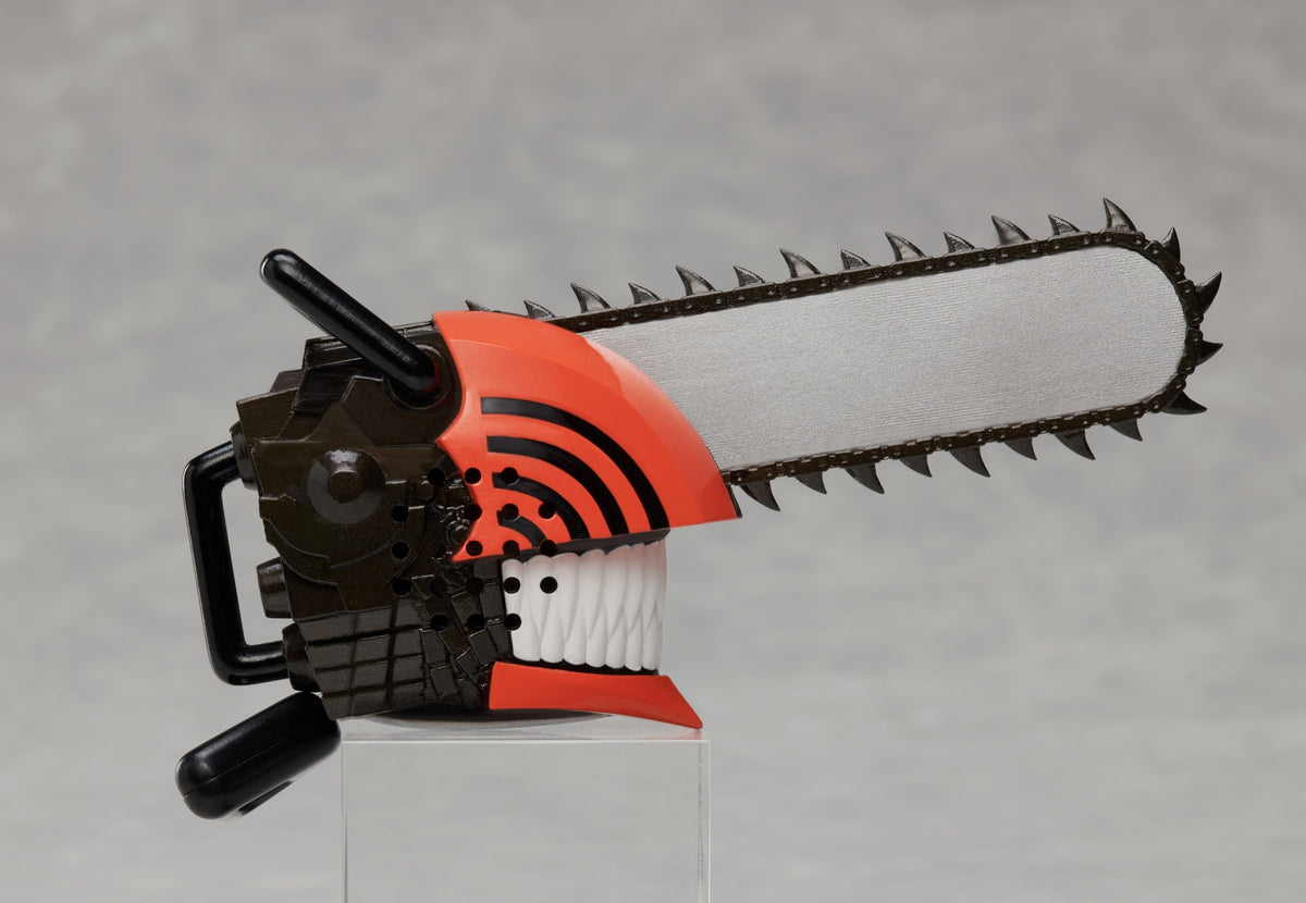 Orange black and silver Chainsaw Man miniature figure with a large chainsaw blade attached to a smiling baring-teeth face