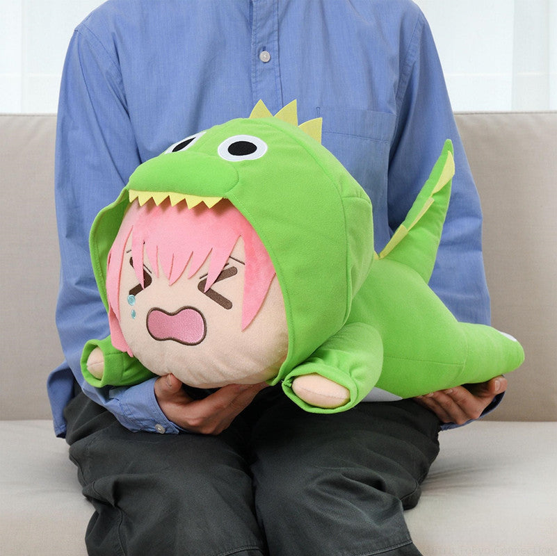 Person holding plush toy of crying character in green dinosaur costume