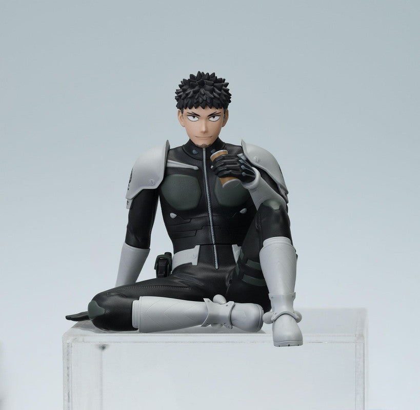 A collectible figure of a man in a black and gray futuristic suit holding a cup of coffee and sitting on a clear block