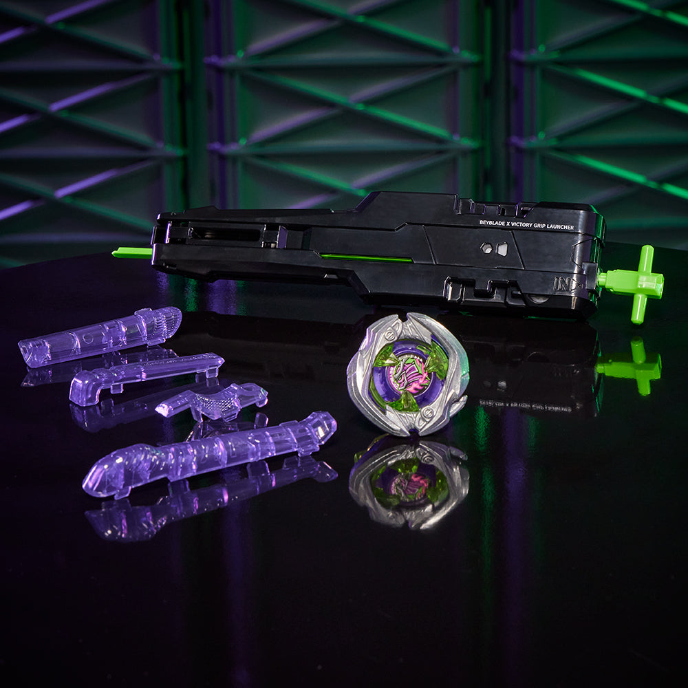 Beyblade X spinning top, black Victory Grip Launcher, and clear component toys displayed