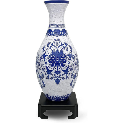 This detailed indigo floral puzzle vase, assembled from visible interlocking pieces, features classic blue and white patterns and stands on a black display base