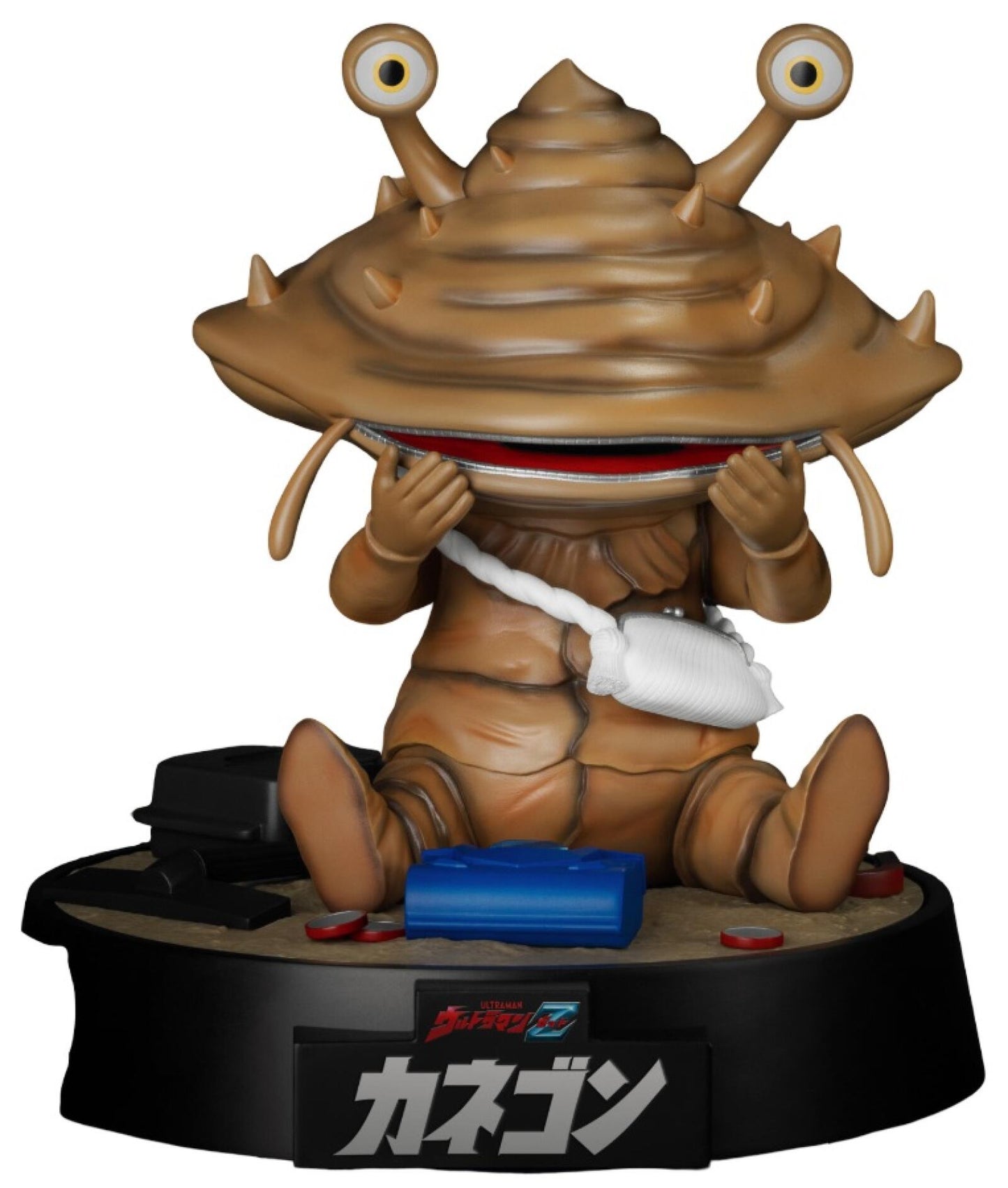 Brown coin monster action figure with large eyes and a zipper mouth holding coins on a black base with Ultraman Z and Kanegon text surrounded by spilled gold coins