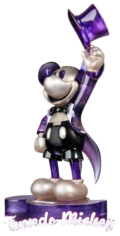 Figure of Belle from a storybook series in yellow dress, holding a book and standing on a themed base