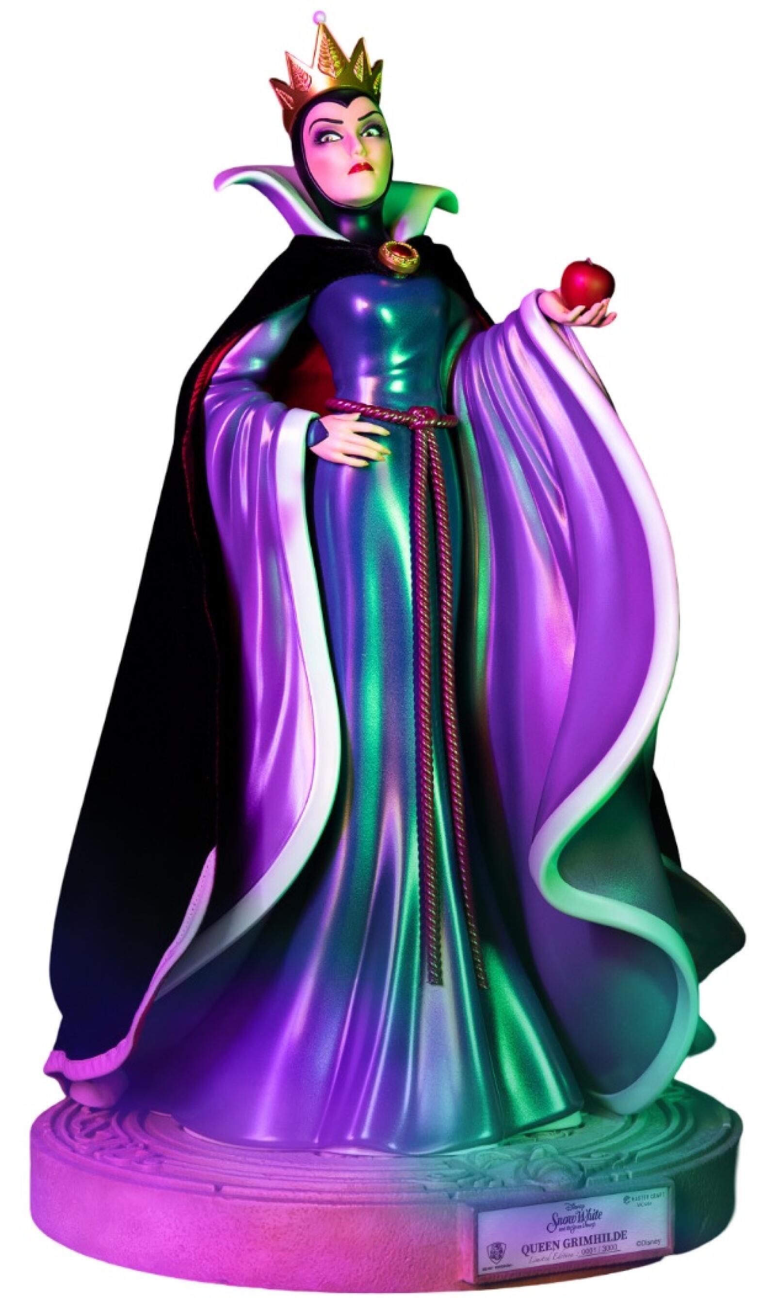 Queen Grimhilde limited edition statue holding a red apple wearing a metallic green and purple dress with a black cape standing on a round stone base