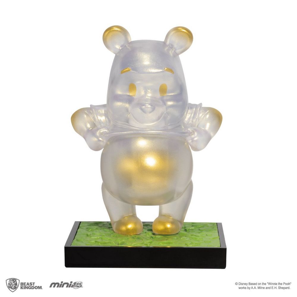 Sparkling clear Winnie the Pooh collectible figure with golden highlights standing on green base