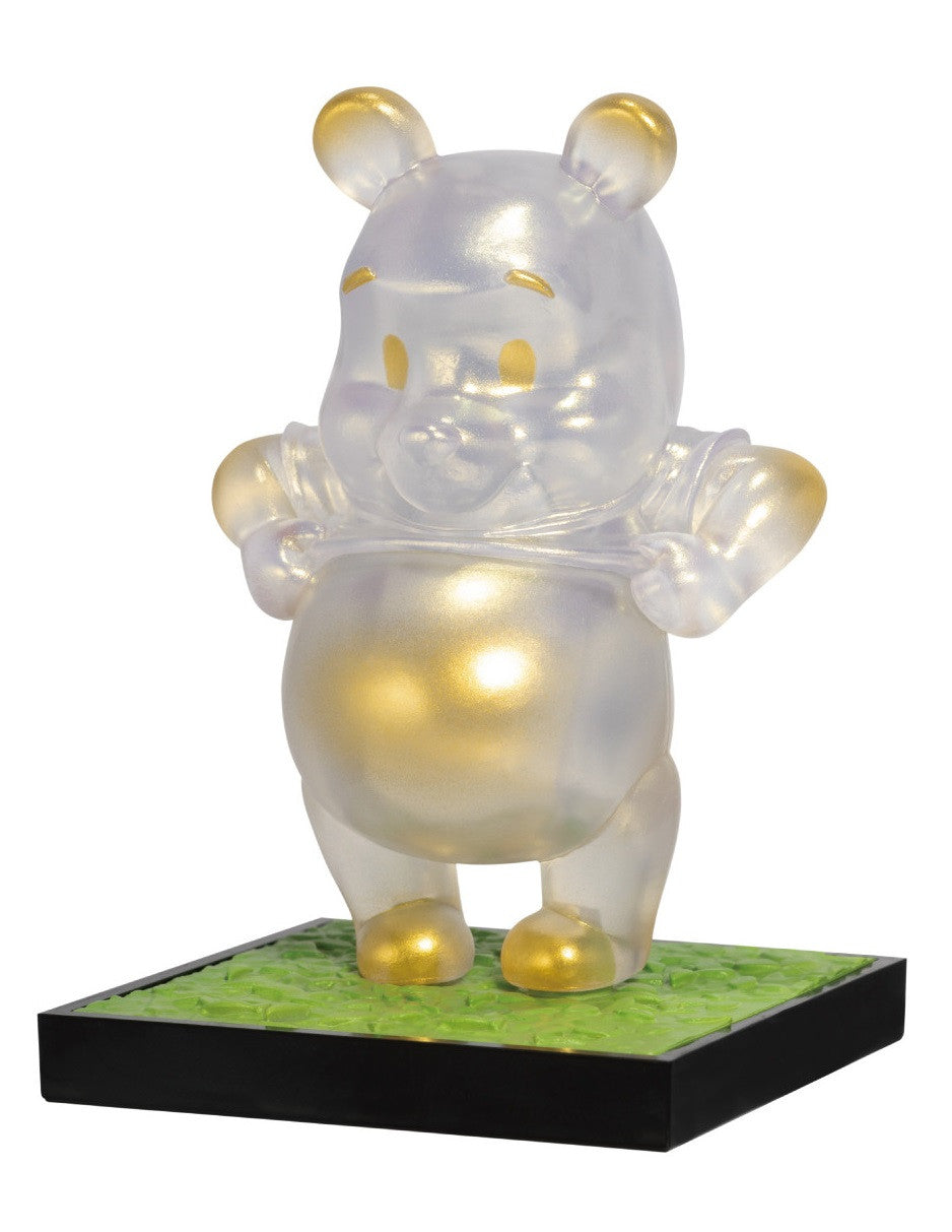 Iridescent Winnie the Pooh figurine with gold accents on a green and black base
