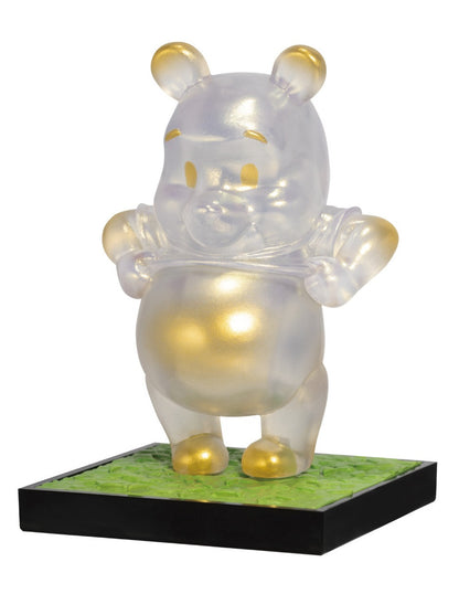 Iridescent Winnie the Pooh figurine with gold accents on a green and black base