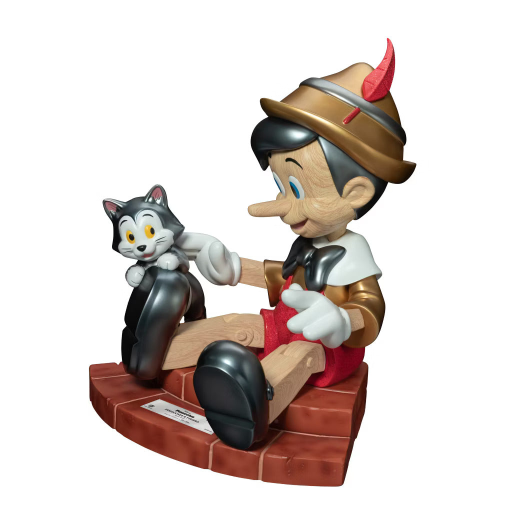Pinocchio and Figaro figurine sitting on a brick base with Pinocchio petting the cat