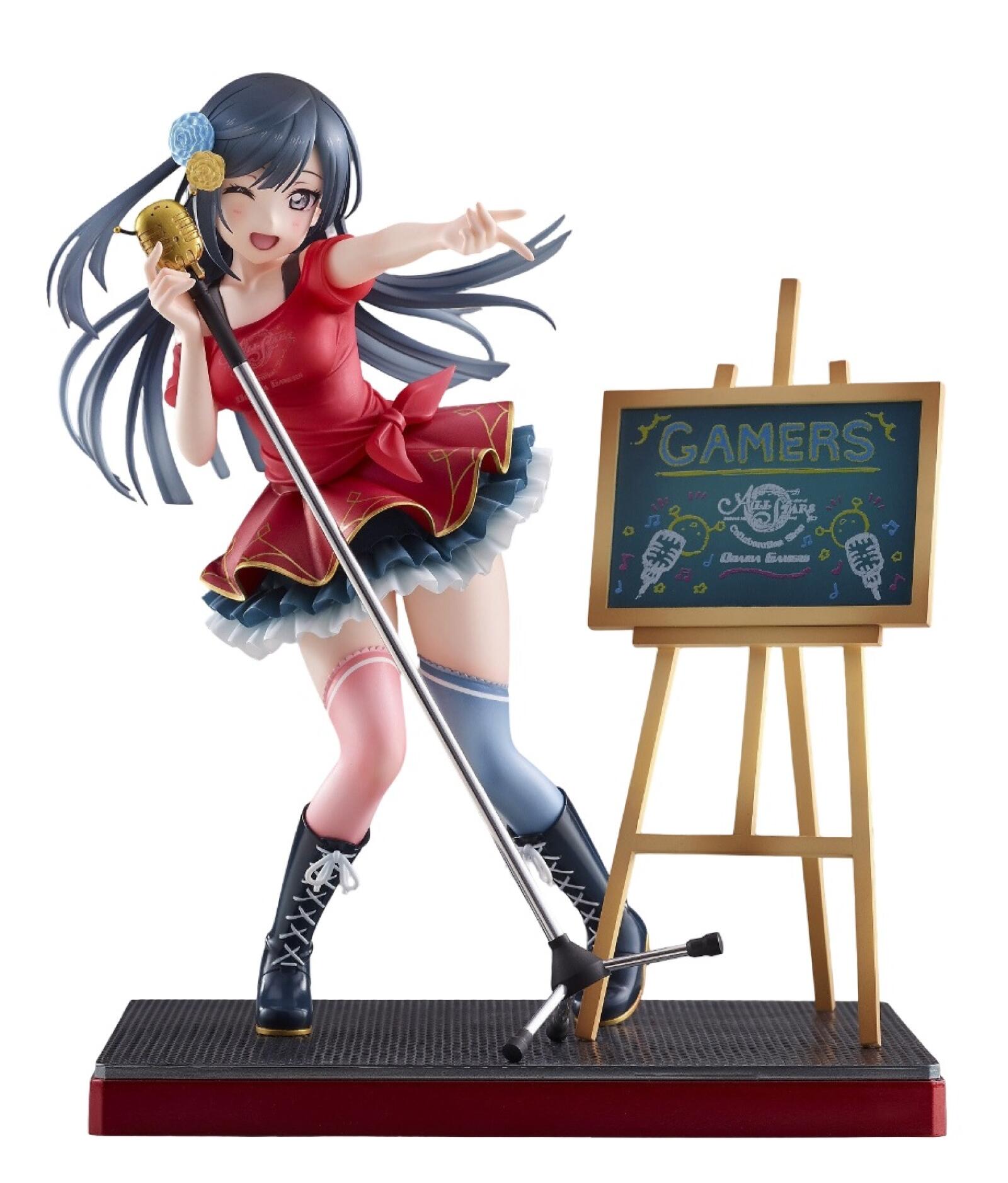 Anime figurine of a girl in a red dress, winking and pointing while singing into a golden microphone, next to a "GAMERS" chalkboard.