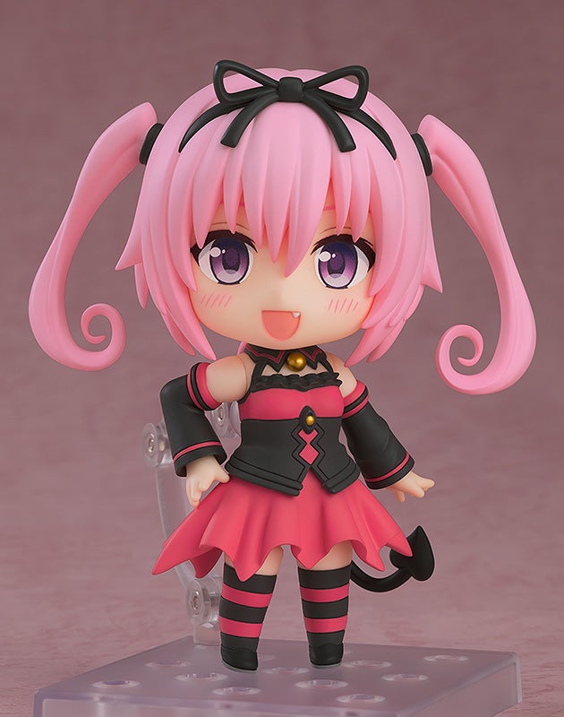 Figure with pink hair in pigtails black bow and black and pink dress with tail on color background with clear stand