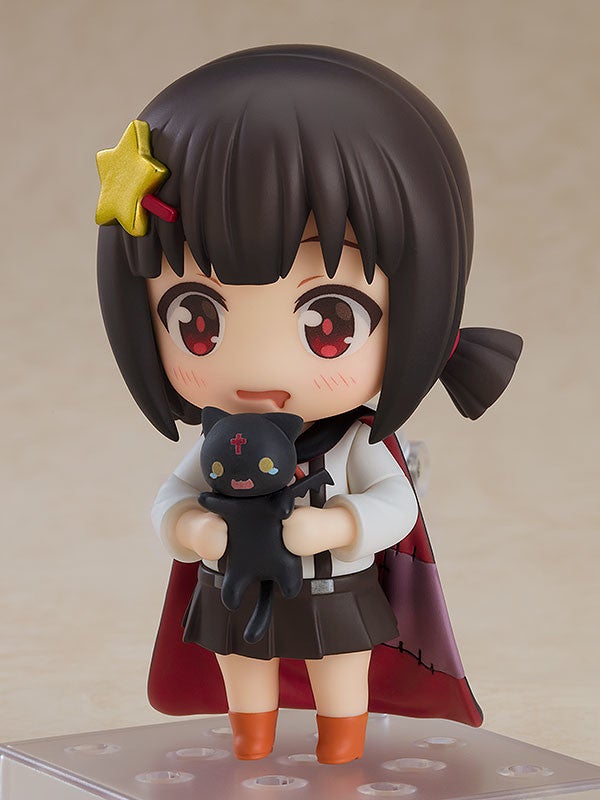 A Nendoroid figure of Komekko holding a small black cat plush with hesitant expression